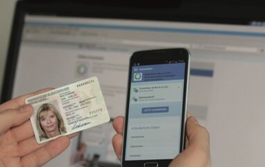 Nutzerin hält Ausweis und Smartphone bereit