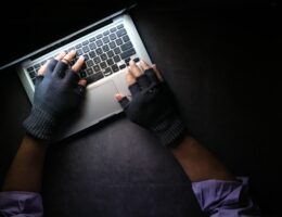 Zwei Hände bedienen in fingerlosen Handschuhen einen Laptop. - Towfiqu Barbhuiya / Unsplash