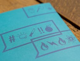 Ein Blatt Papier ist mit Sprechblasen bedruckt, in denen sich unterschiedliche Emojis befinden. Mika Baumeiser / Unsplash