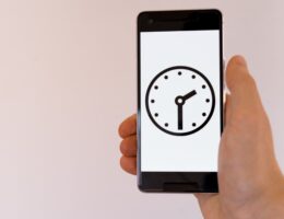 Digital Detox: Ein Smartphone, das eine Uhr auf dem Display anzeigt. Bild: Markus Winkler / Unsplash